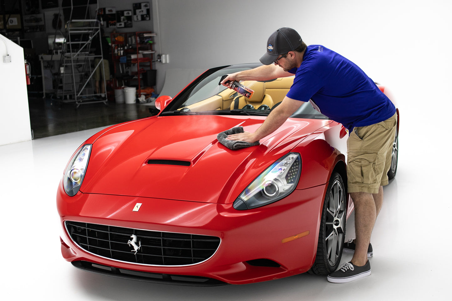 Detailer applying P&S Bead Maker as drying aid on red sports car
